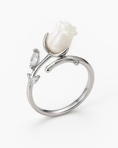 Silver ring with a white rose design on a white background