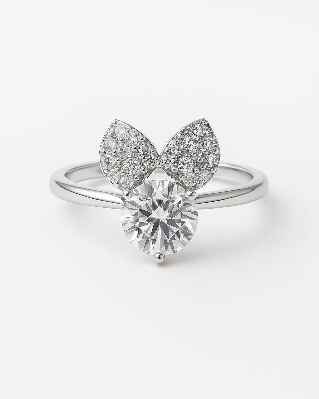 Silver ring with diamond and leaf-like design on a white background