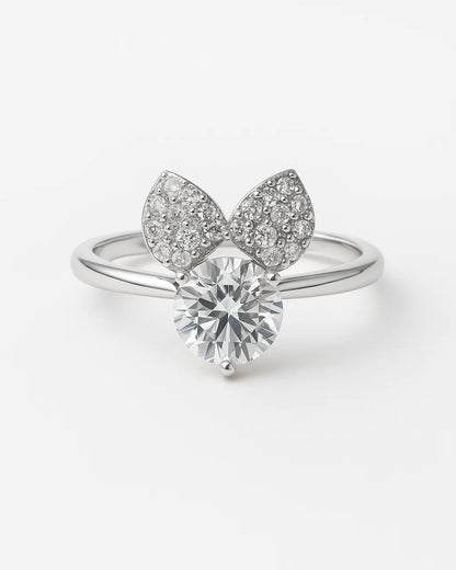 Silver ring with diamond and leaf-like design on a white background