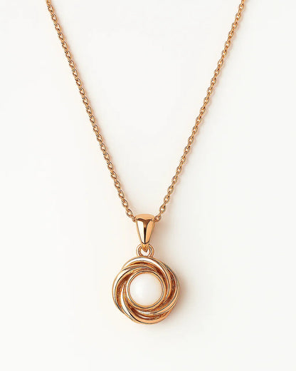 Rose gold necklace with a circular pendant on a white background