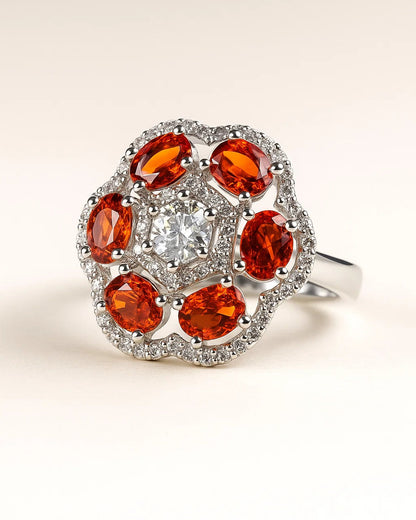 Ring with orange gemstones and a central diamond on a beige background