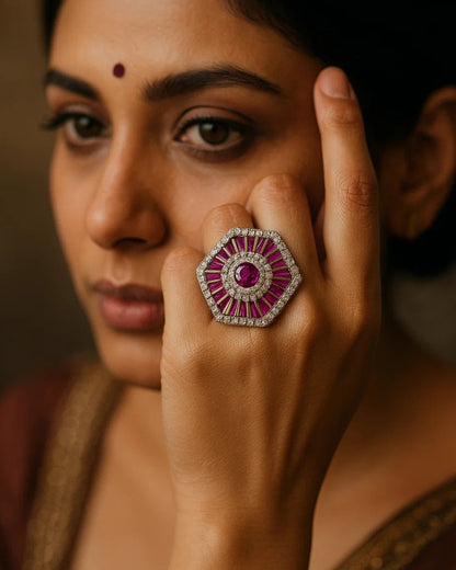 Woman wearing a large, ornate ring with a prominent gemstone against a blurred background