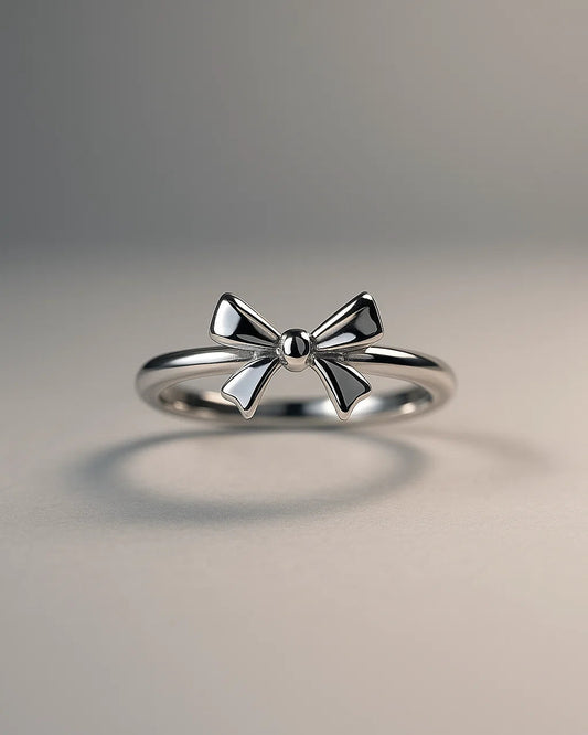 Silver bow-shaped ring on a gray background