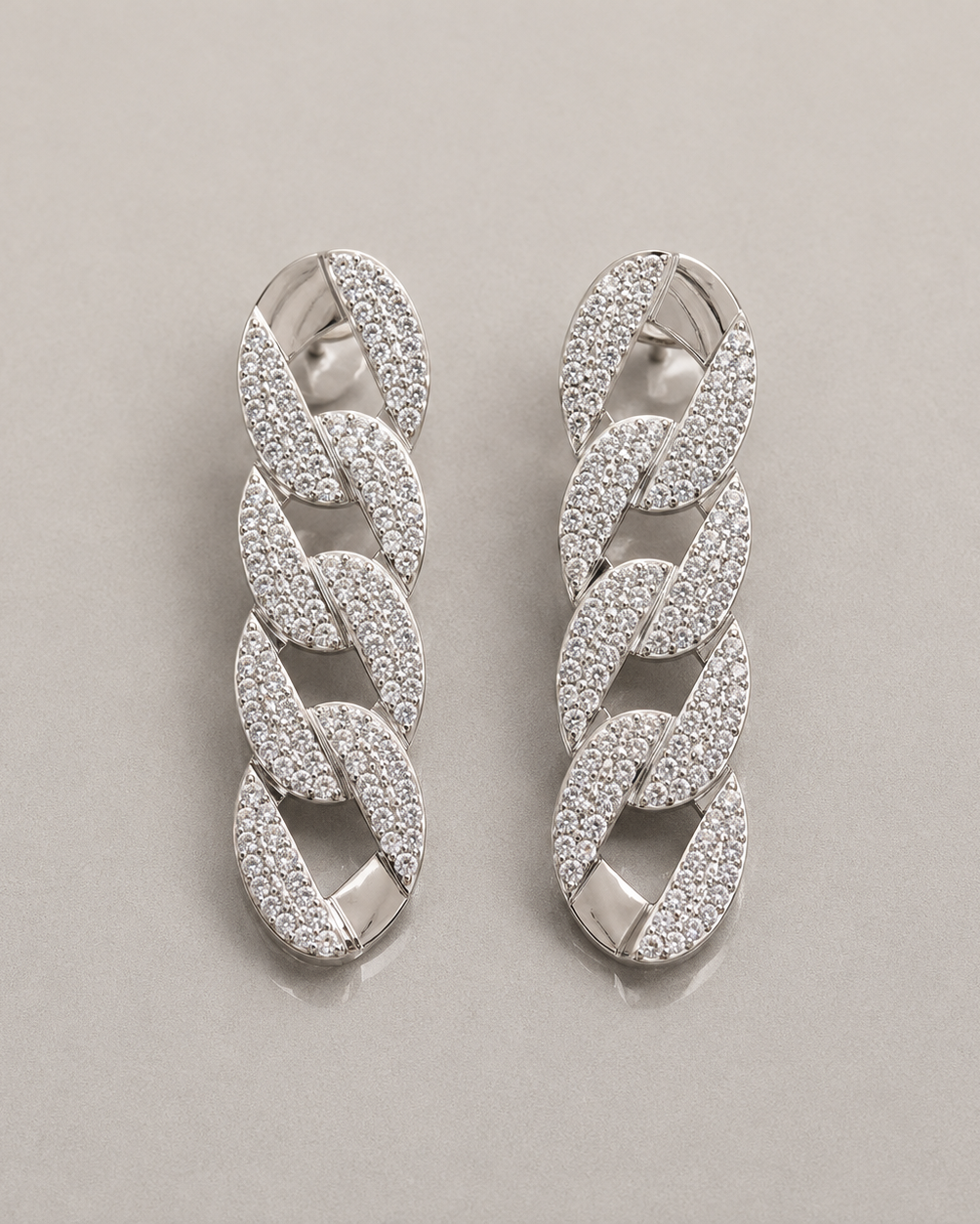 Pair of silver chain-style earrings on a light gray background
