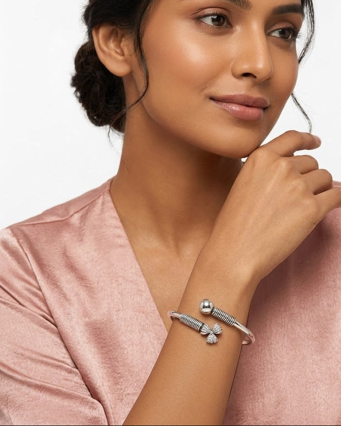 Woman wearing a silver bracelet on a plain background
