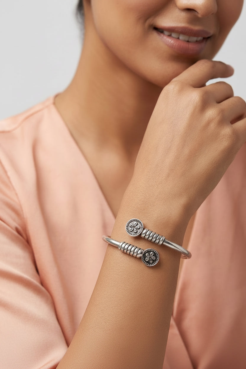 Silver bracelet on a wrist with a neutral background