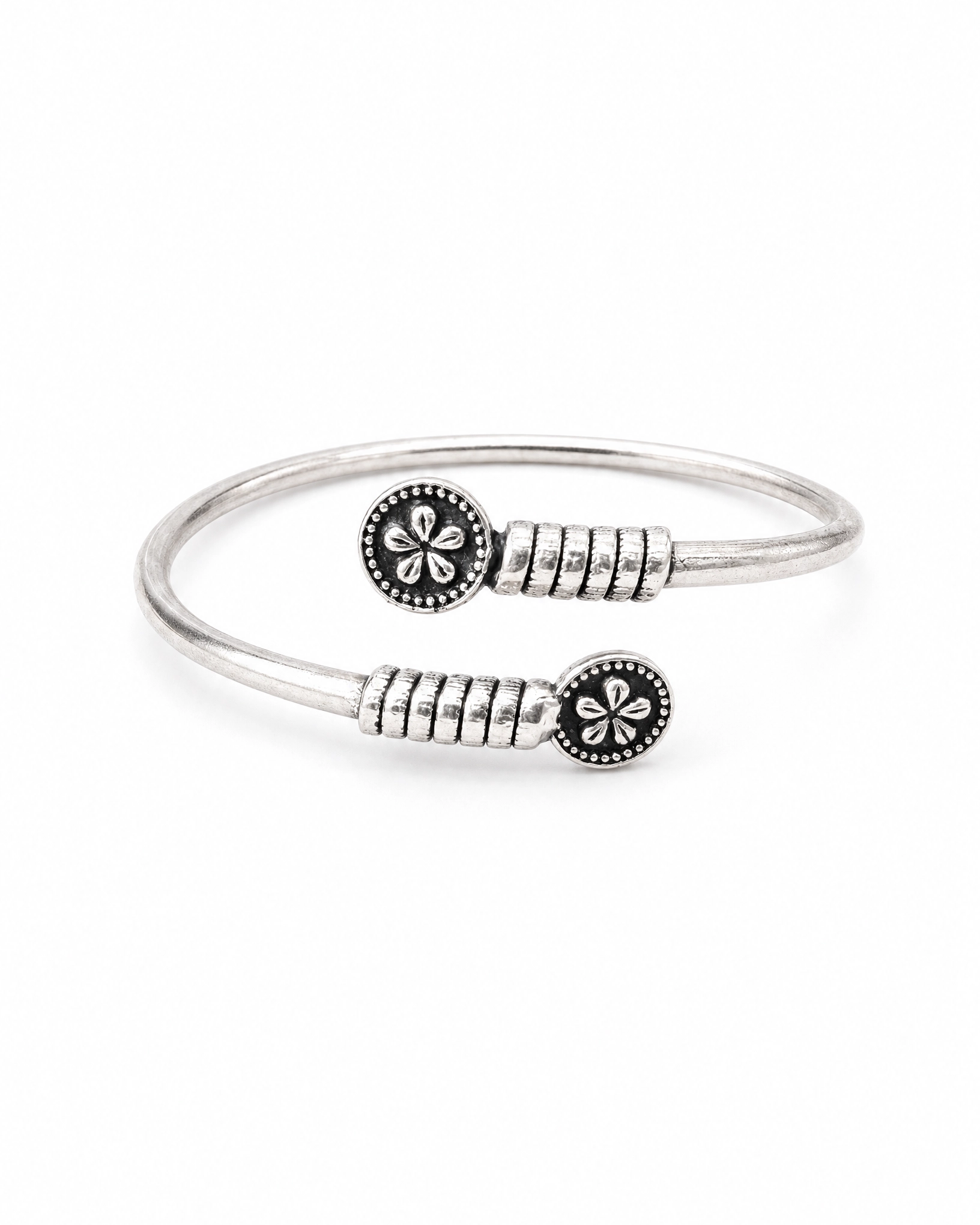 Silver bracelet with floral designs on a white background