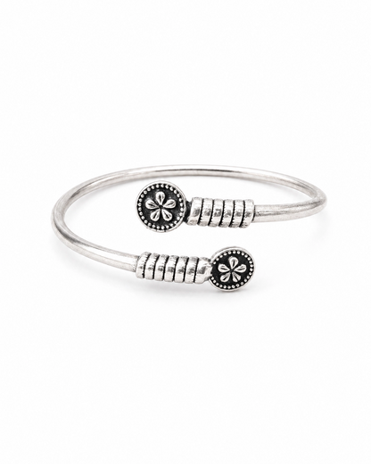 Silver bracelet with floral designs on a white background