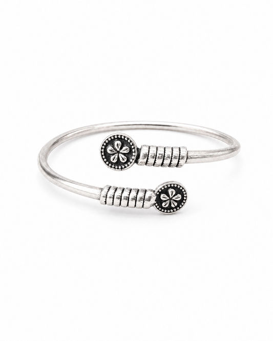 Silver bracelet with floral designs on a white background