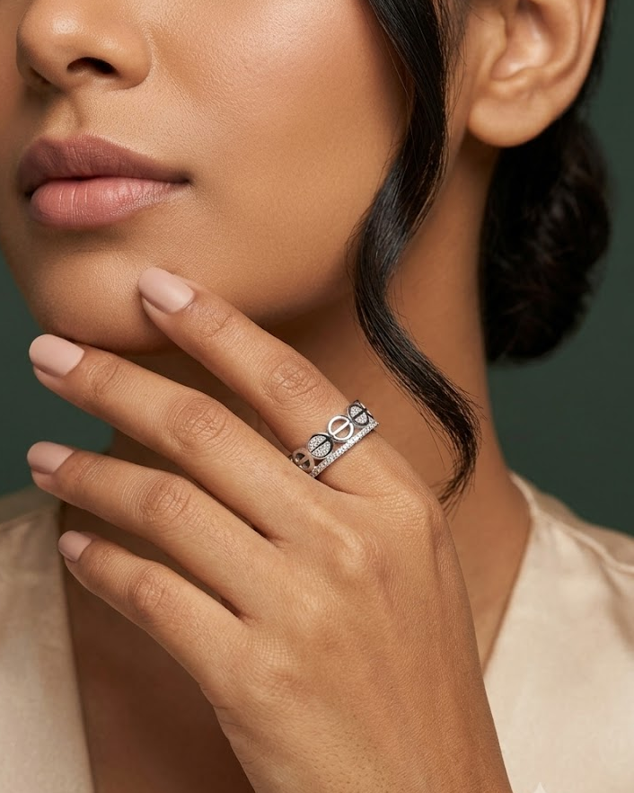 A close-up lifestyle shot of a model wearing a silver ring with a textured, geometric pattern on her finger.